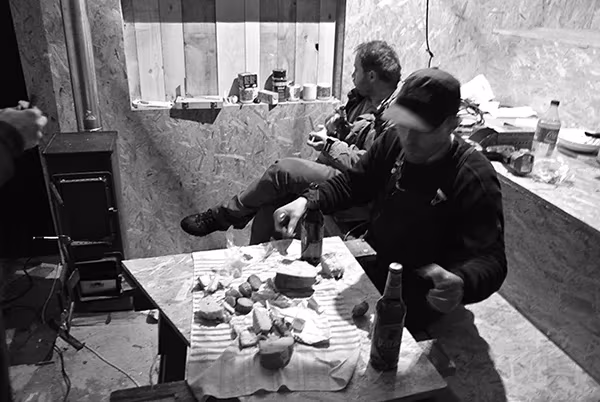 Dos personas comparten comida y bebida en la mesa de la Cabaña en Bohemia, en blanco y negro