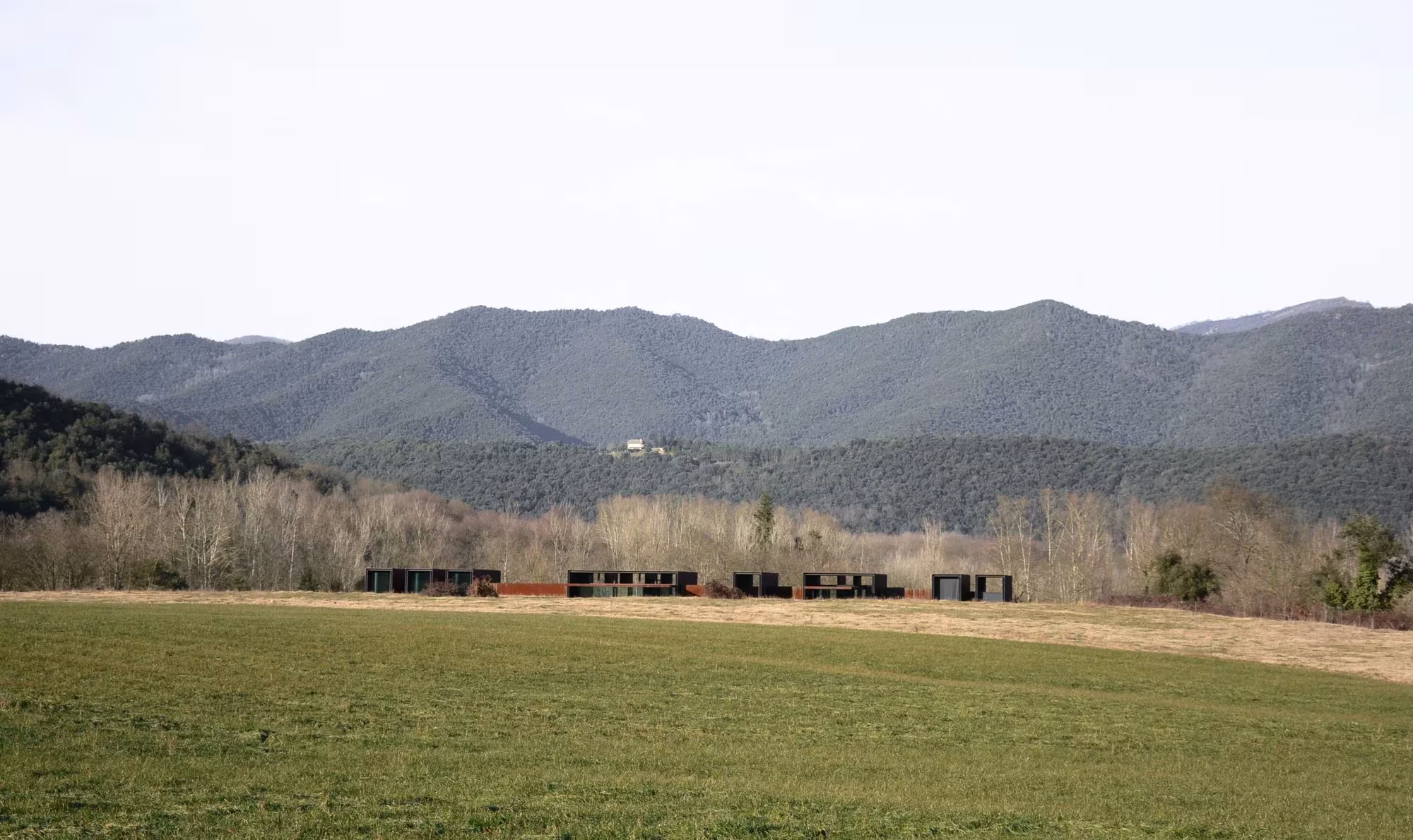 Casa Horizonte de RCR, línea baja y oscura en el horizonte de un prado de la Garrotxa ante los Pirineos