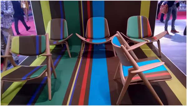 Butacas CH28 de Wegner con tapicerías de colores sobre una alfombra de rayas anchas multicolores