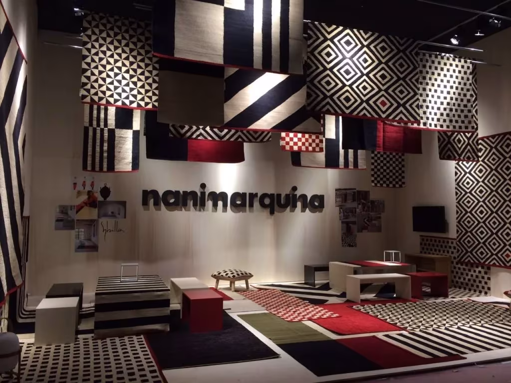 Stand de Nani Marquina en la Feria del Mueble de Milán con alfombras Mélange colgadas y en el suelo