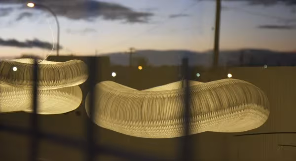 Lámparas cloud de Molo Design encendidas junto a una ventana al anochecer, con luz cálida a través del papel