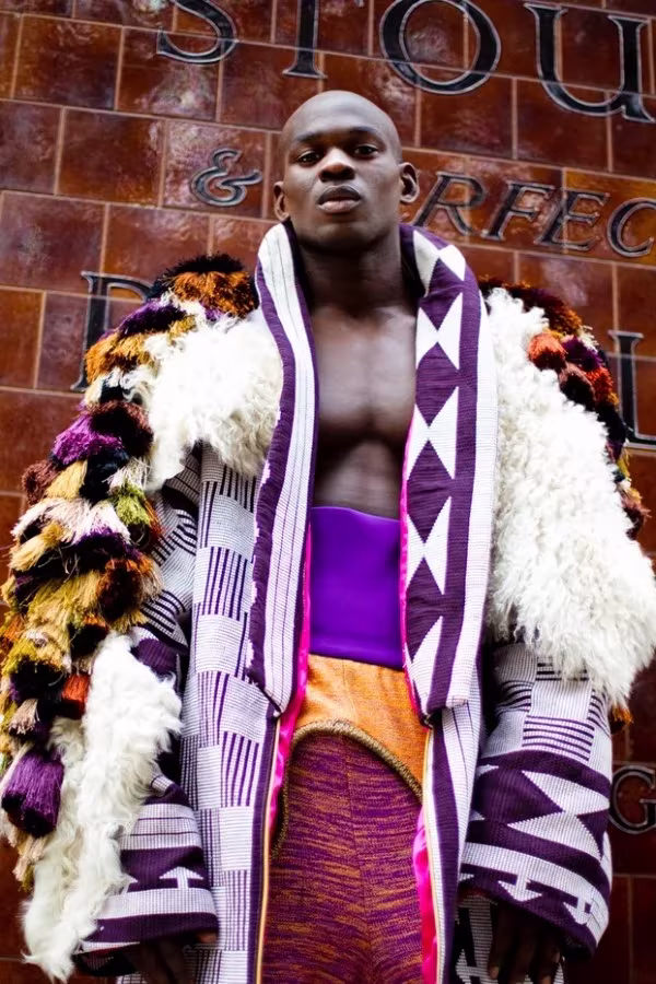 Modelo con abrigo de piel y tejido estampado en morado y blanco, de la sección de moda de «Making Africa»