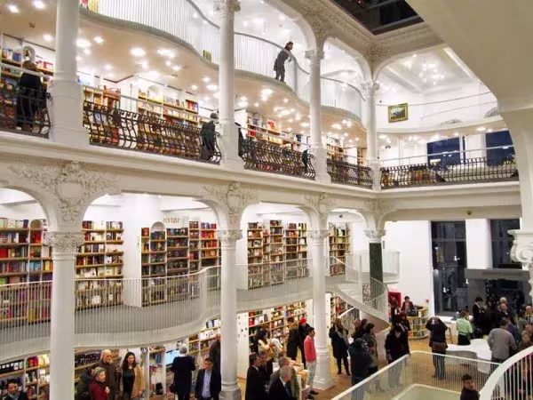 Interior de la librería Carturesti Carusel en Bucarest con balcones blancos, columnas y estanterías llenas