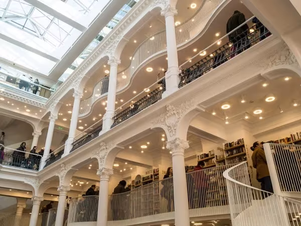 Galerías de columnas de fundición blancas y lucernario del siglo XIX en la librería Cărturești Carusel de Bucarest