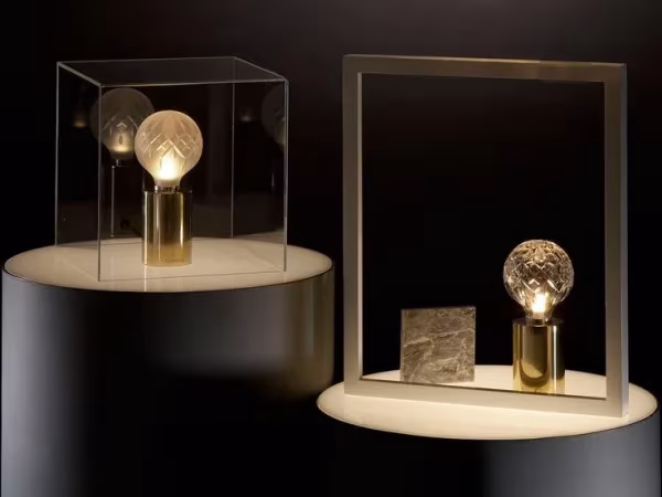 Lámparas de bombilla facetada de Lee Broom con base dorada expuestas en vitrinas de cristal
