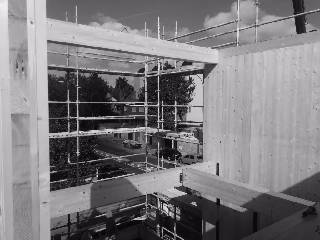 Obra de la Casa ÁBATON en Aravaca en blanco y negro, con muros de madera maciza y andamios