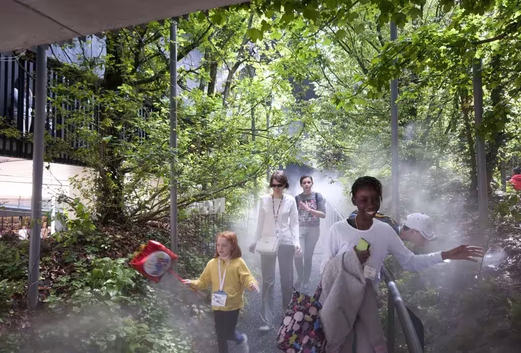 Familia paseando entre árboles y niebla en el pabellón de Austria «Respirar» de la Expo de Milán