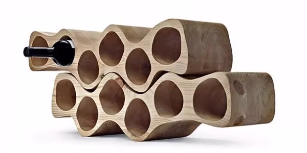 Botellero modular de madera clara con huecos redondos en forma de panal y una botella