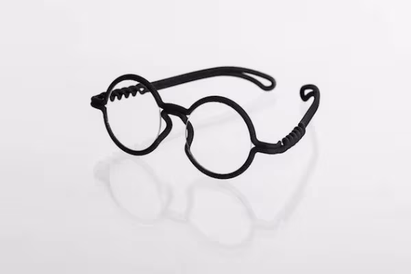 Gafas MONO redondas de montura negra impresas en 3D en una sola pieza, con su reflejo sobre fondo blanco