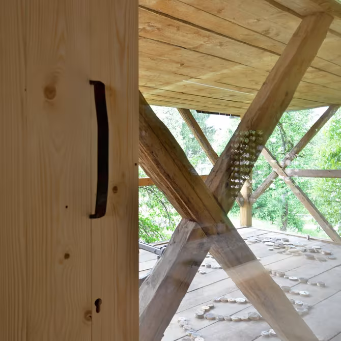 Detalle del forro de madera y las cruces estructurales del apartamento en un granero alpino de OFIS