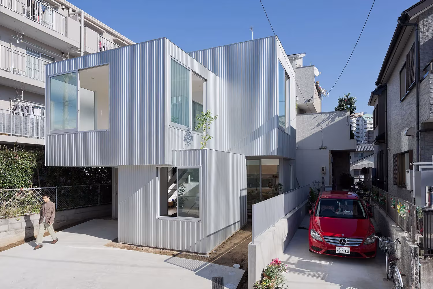 Casa Chayagasaka de Tetsuo Kondo, cajas de chapa blanca apiladas en una calle estrecha de Nagoya