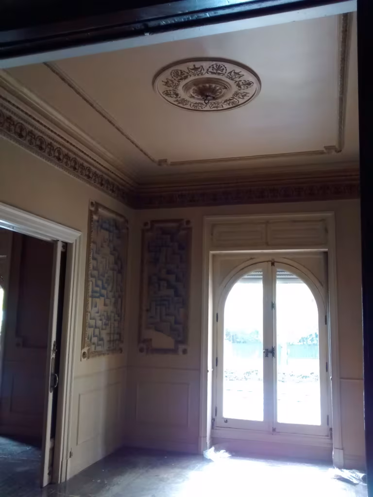 Estancia de la vivienda de 1927 antes de la reforma, con rosetón en el techo y balcón en arco