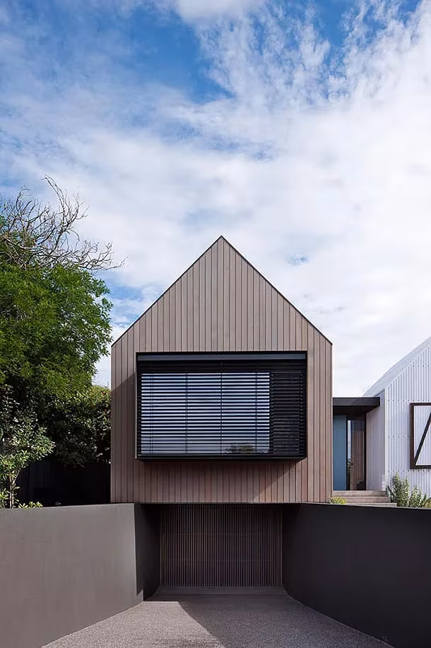 Pabellón de madera a dos aguas de Seaview House con contraventana de lamas sobre un garaje de hormigón
