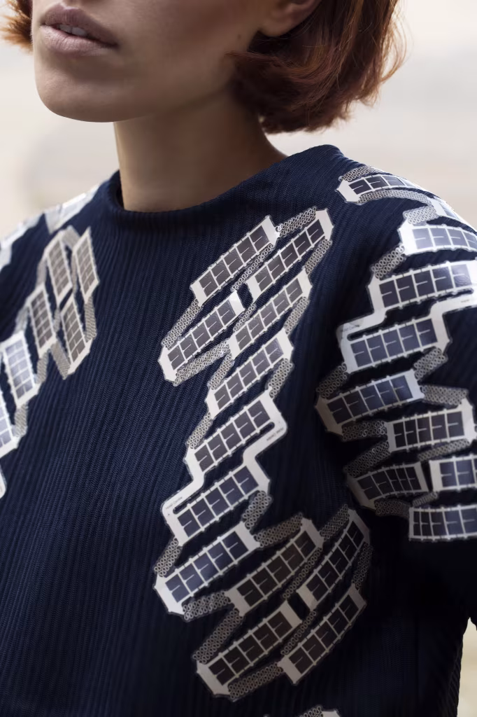 Jersey azul marino de Pauline van Dongen con pequeñas células solares cosidas en hombros y mangas