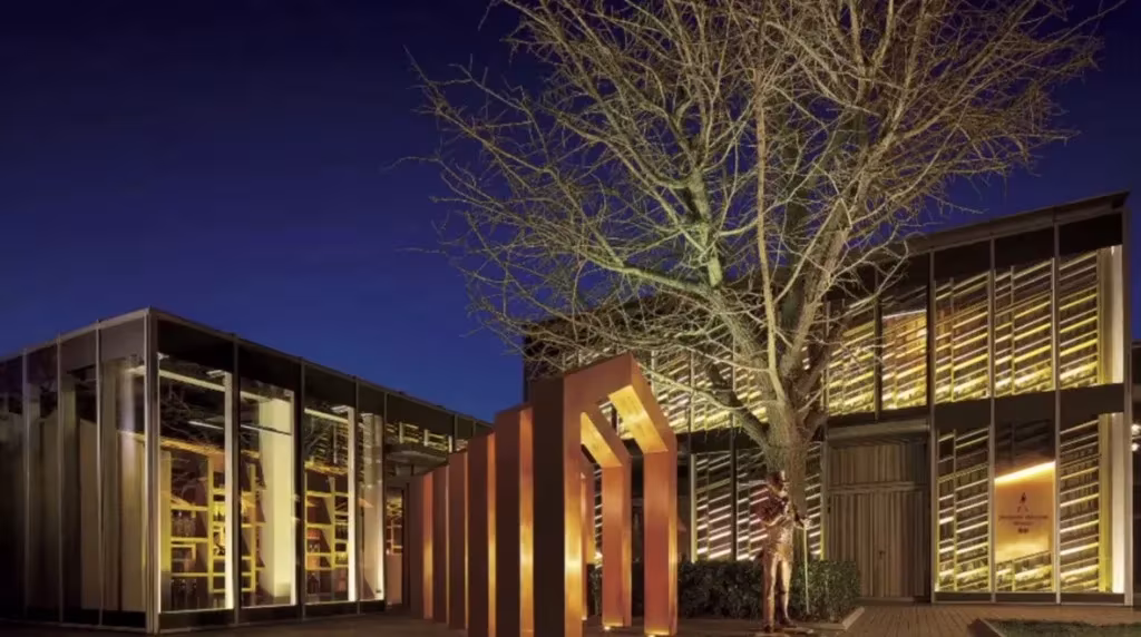 Johnnie Walker House de Love en Shanghái de noche, con fachadas de vidrio iluminadas y un gran árbol