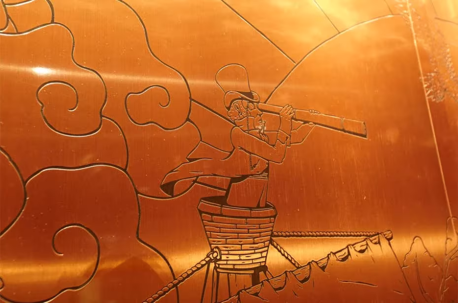 Pared de cobre grabada con un dibujo de un hombre sobre un barril entre nubes, en la Johnnie Walker House