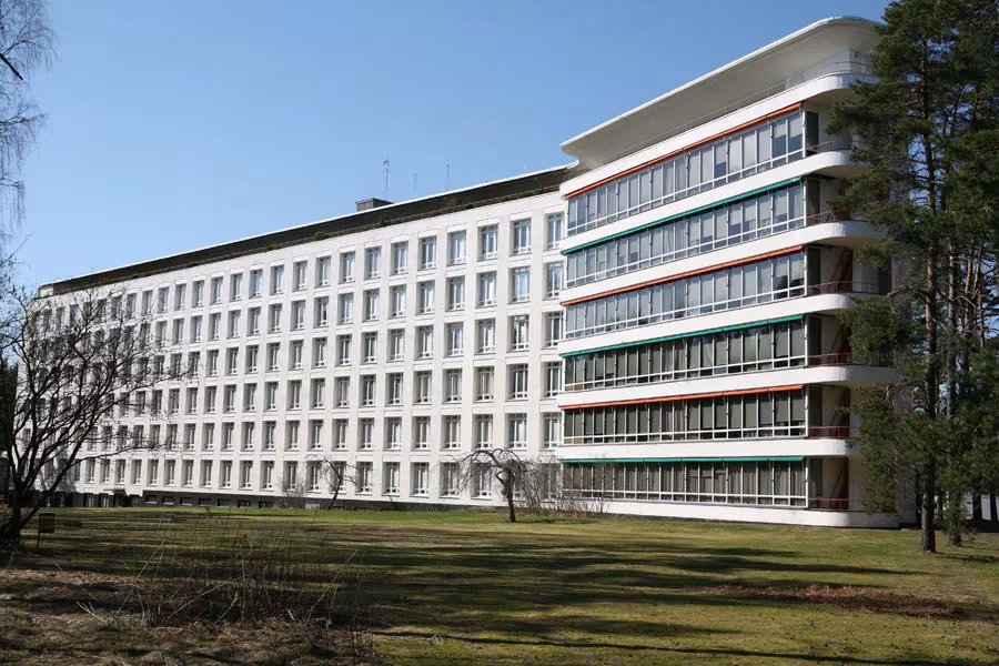 Sanatorio de Paimio de Alvar Aalto, bloque blanco con terrazas en voladizo entre pinos y césped