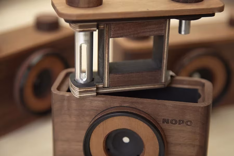 Detalle de una cámara estenopeica Nopo de madera abierta mostrando el mecanismo interior de arrastre