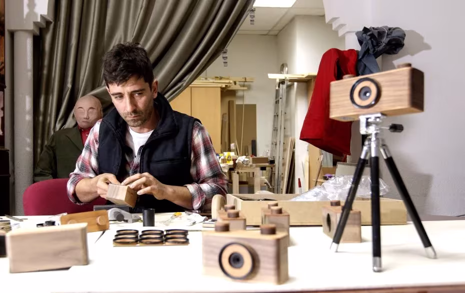 Antonio Cañadas monta a mano cámaras estenopeicas de madera en su taller, con piezas sobre la mesa
