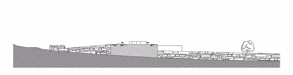 Alzado norte de la Hill Cork House de Contaminar Arquitectos integrada en la pendiente de la colina