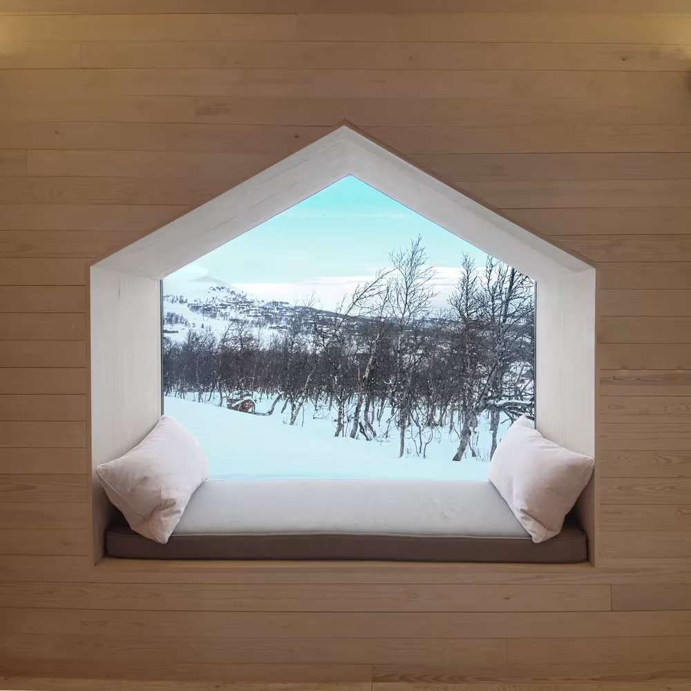 Banco con cojines bajo una ventana en forma de casa con vistas a la montaña nevada en el Split View Mountain Lodge