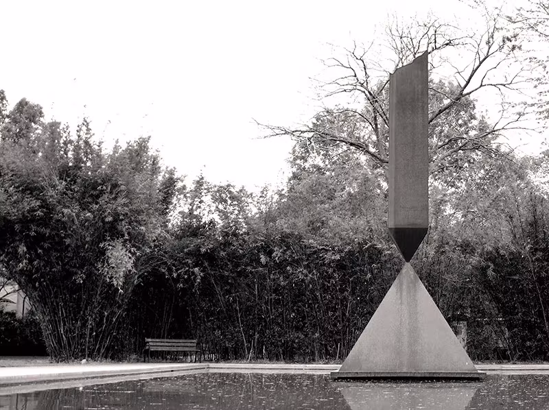 Escultura Broken Obelisk de Barnett Newman junto a la Rothko Chapel de Houston, en blanco y negro