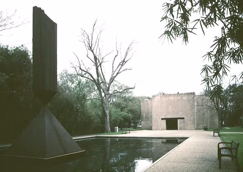 Broken Obelisk de Barnett Newman sobre un estanque frente a la fachada de ladrillo de la Rothko Chapel