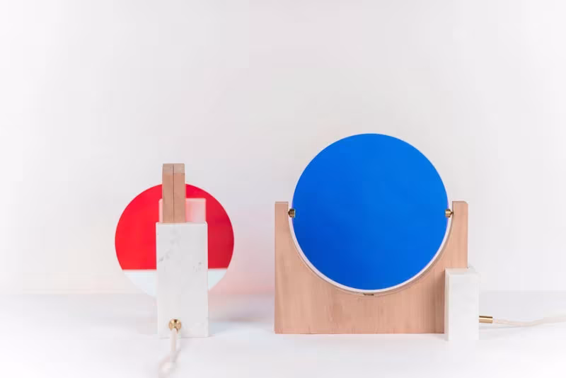 Dos lámparas Day & Night, una con disco rojo y otra con disco azul, sobre fondo blanco