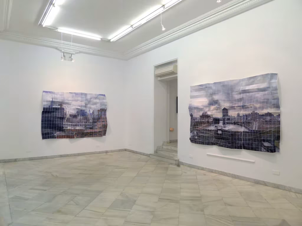 Sala de galería blanca con suelo de mármol donde cuelgan dos obras fotográficas de Germán Gómez