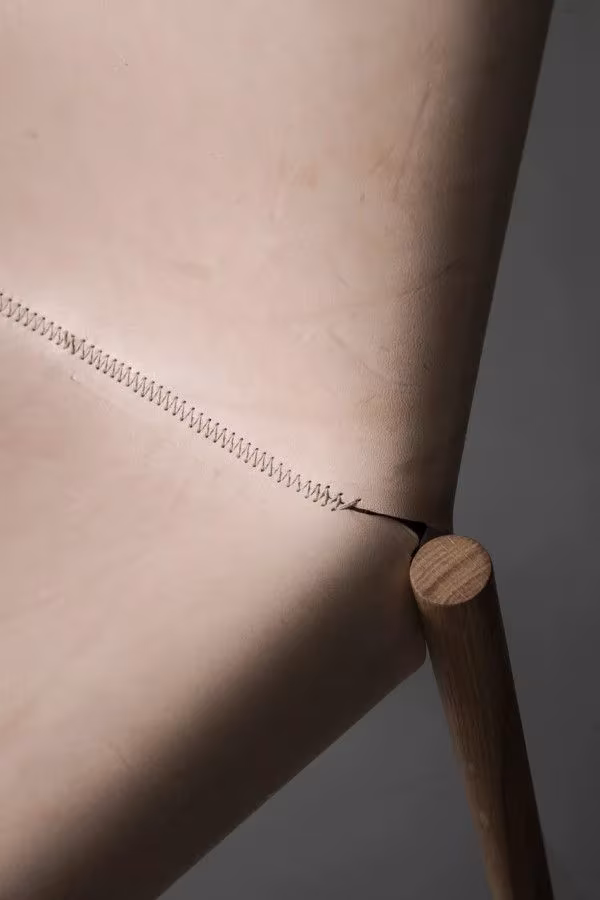 Detalle del cosido del cuero natural y la pata de madera de la Hide Chair de Kristalia