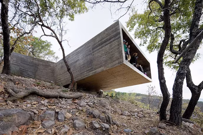 Mirador de hormigón de Aravena en Las Cruces volado sobre una ladera rocosa entre árboles