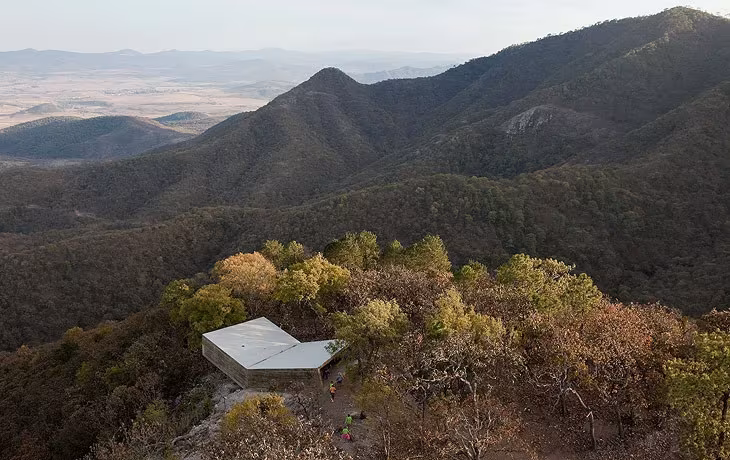 Mirador de Las Cruces de Aravena posado en una cresta boscosa con un valle montañoso al fondo