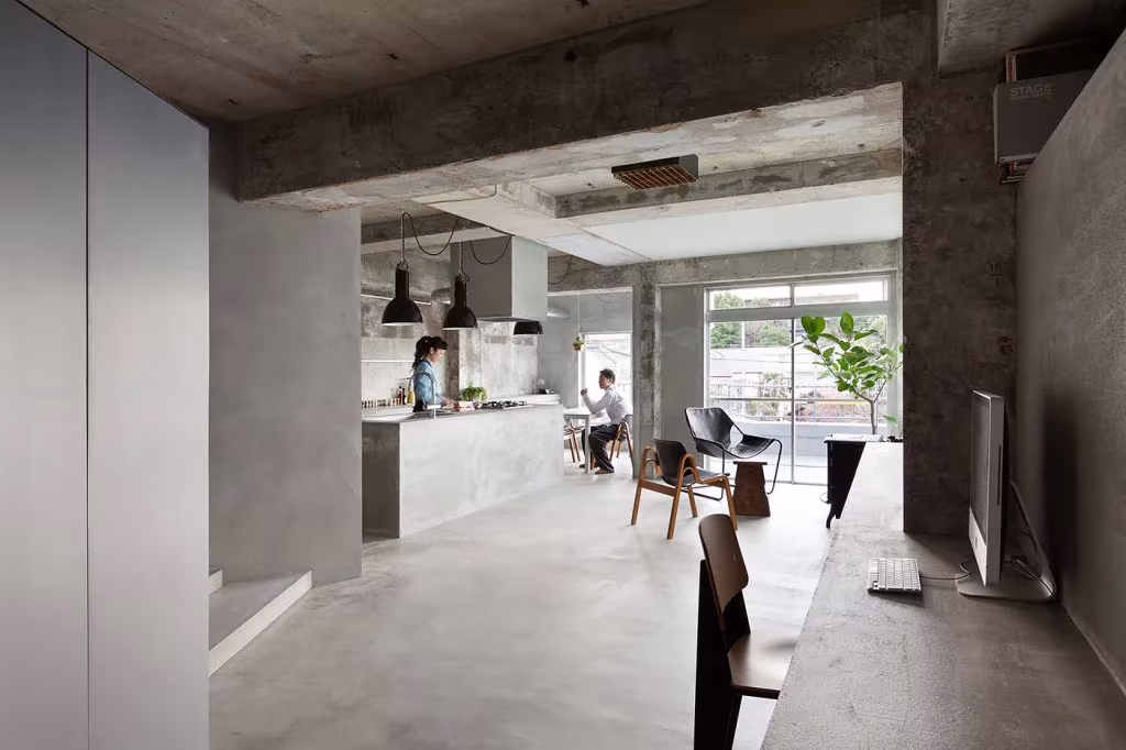 Apartamento de Keiichi Kiriyama en Tokio con techo de hormigón visto, cocina al fondo y ventanal