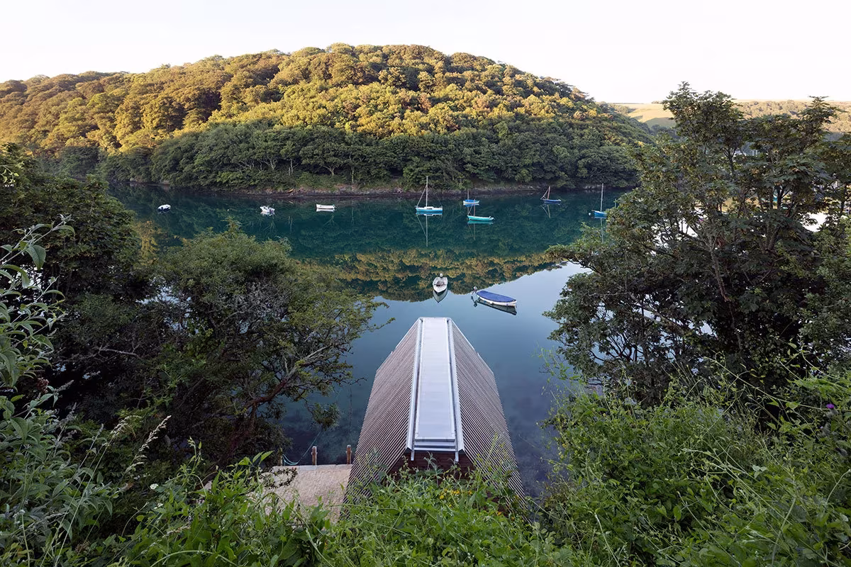 Vista cenital del Berberis Boathouse de Wimshurst Pelleriti sobre el río Yealm rodeado de arbolado, Devon