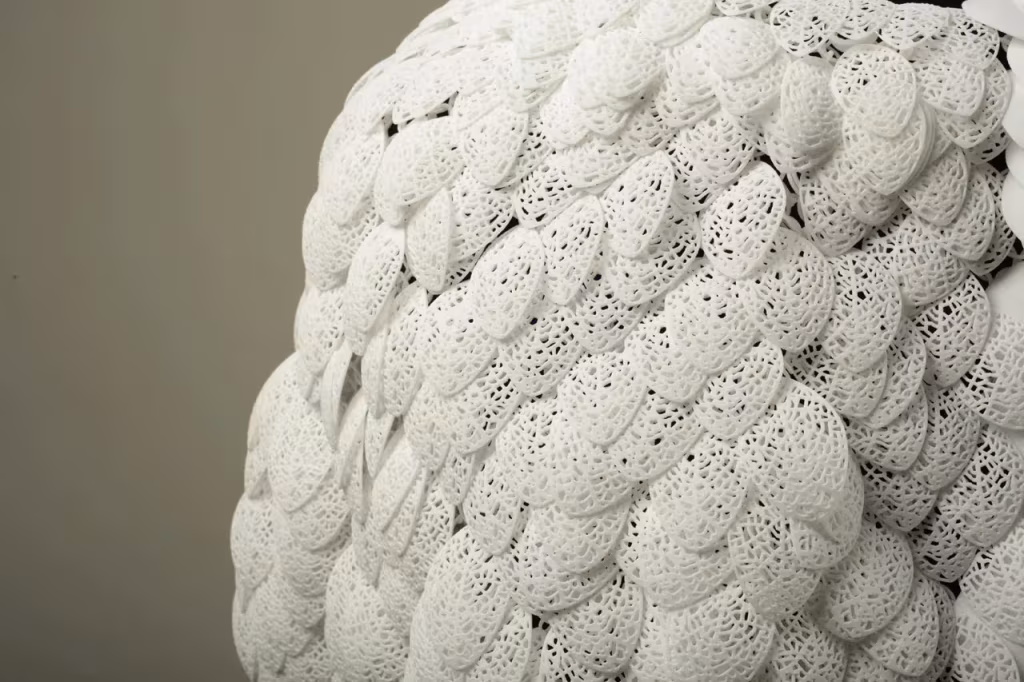 Detalle de las escamas blancas perforadas que forman la capa impresa en 3D