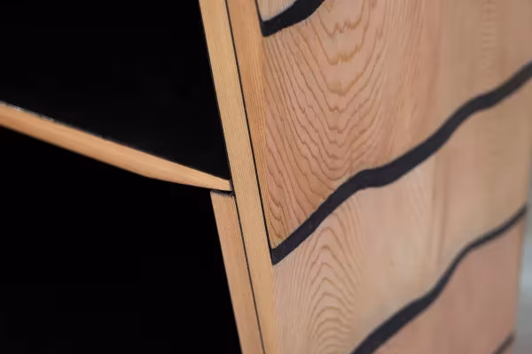 Detalle del canto de cedro del mueble Fuse con las juntas onduladas de resina de mármol negro