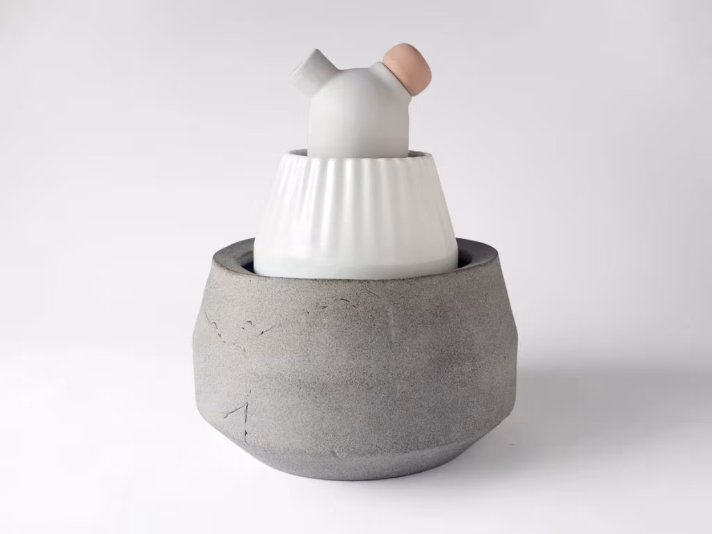 Jarrón Biophilia de Stoft Studio con pieza de porcelana blanca acanalada sobre una base de hormigón gris