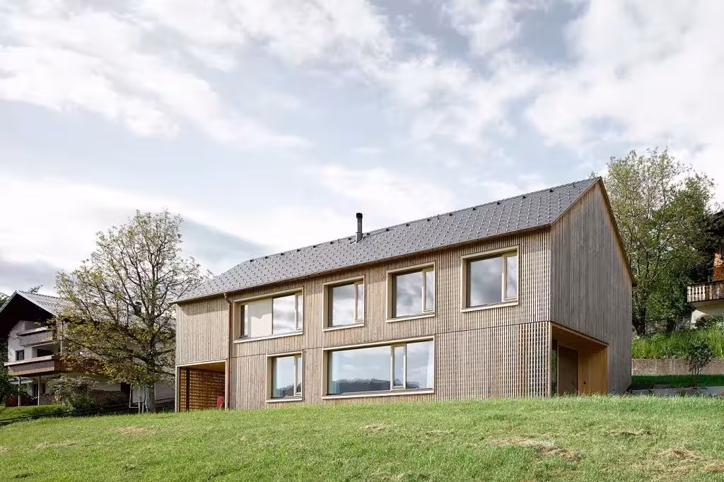 Fachada lateral de madera con ventanas cuadradas de la Casa de Julia y Björn junto a otras casas de Egg