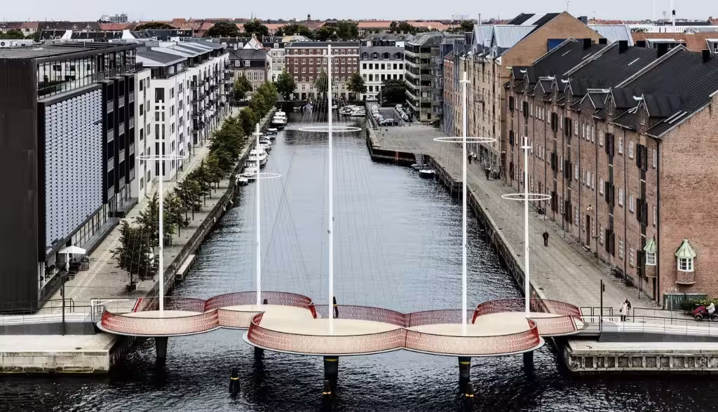 Vista elevada de Cirkelbroen sobre el canal de Christianshavn con barcos amarrados y almacenes de ladrillo