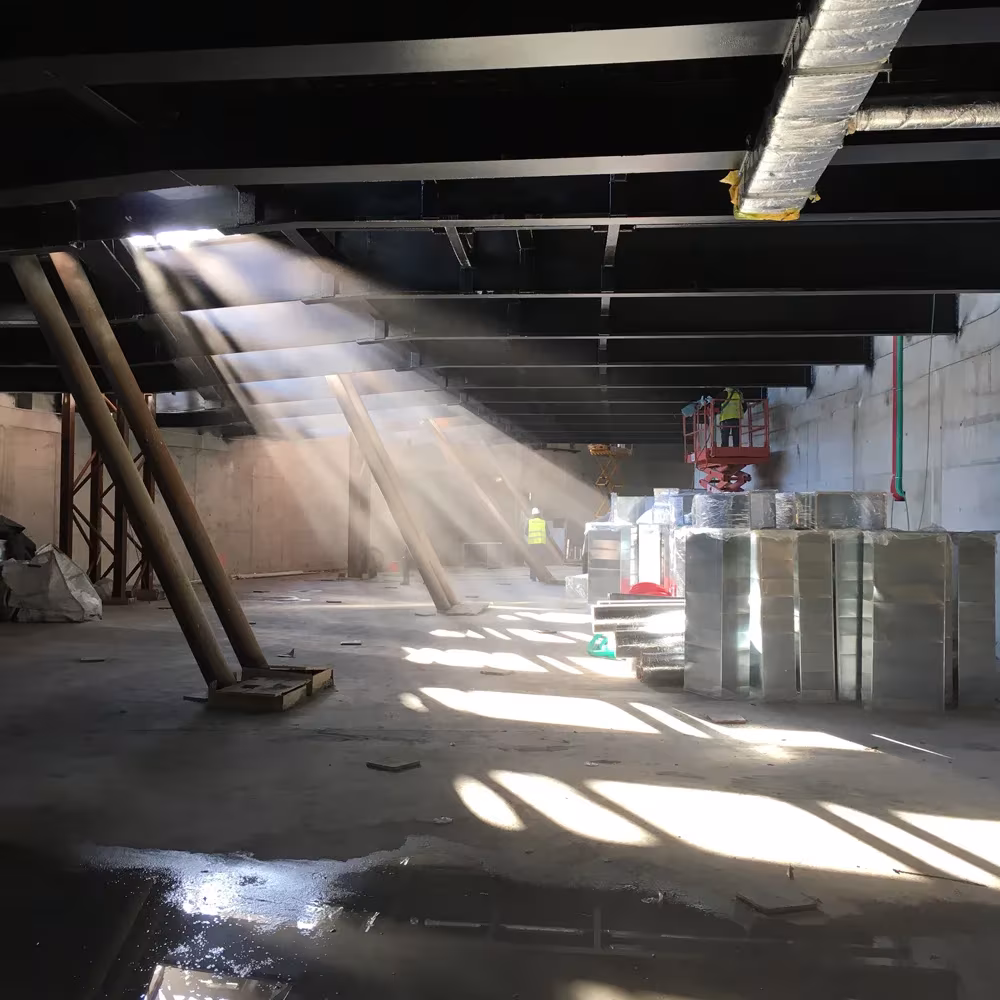 Interior del MAAT en obra con pilares inclinados y luz entrando en haces por la fachada