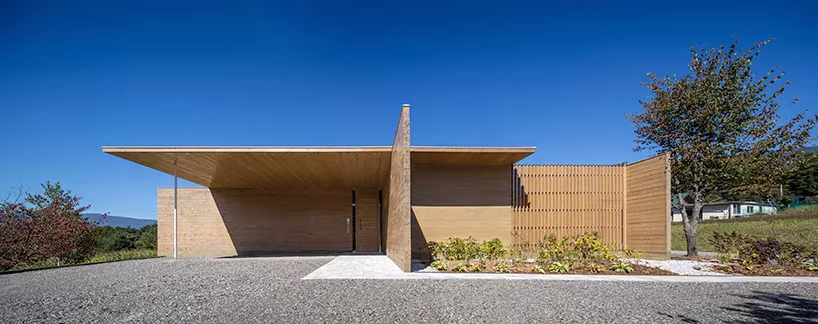 Volumen bajo con gran voladizo de la Solid Cedar House de Shigeru Ban en Hokuto bajo cielo azul