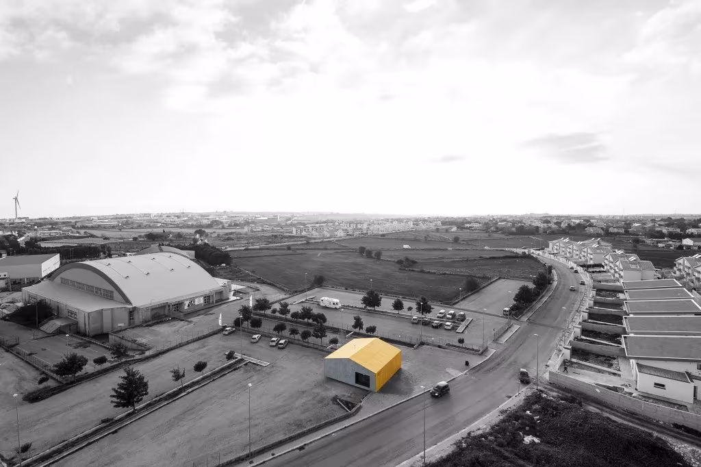 Vista aérea en blanco y negro del entorno del Eco Bar en Ragusa, con un pabellón y una calle