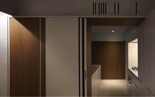 Pieza central de almacenaje de la Casa BHMM con puertas de madera y blancas entreabiertas
