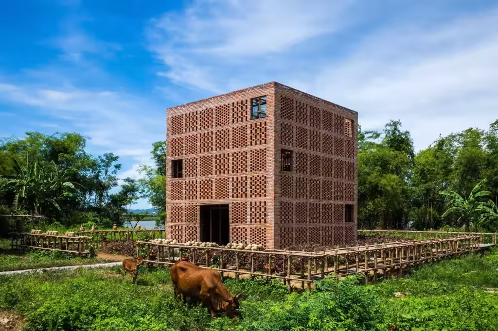 Terra Cotta Studio de Tropical Space, cubo de celosía de ladrillo junto al río Thu Bon con vacas pastando