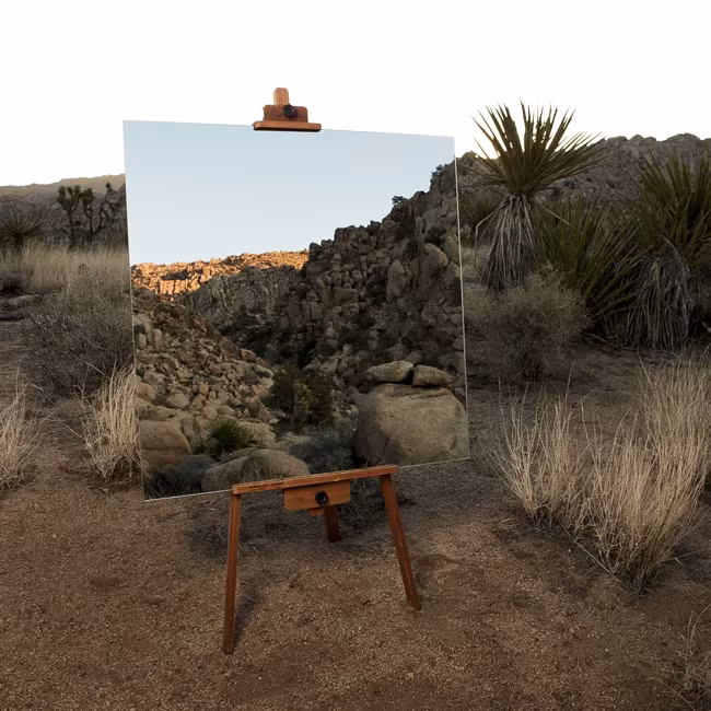 Espejo sobre un caballete en el desierto de Joshua Tree reflejando rocas, obra de Daniel Kukla