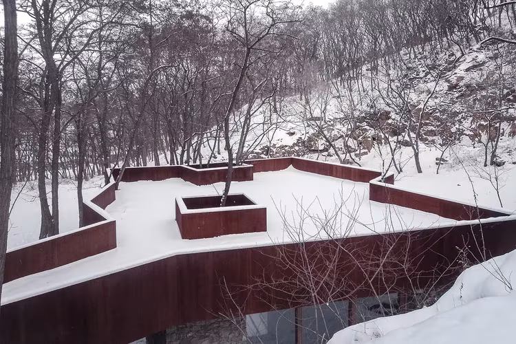 Cubierta nevada de la Rockview Teahouse con borde de acero corten y huecos para los árboles