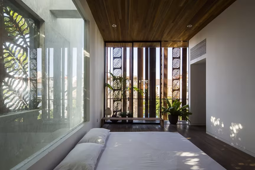 thong house dormitorio Dormitorio alargado de la Thong House con techo de madera y celosías de hojas al fondo