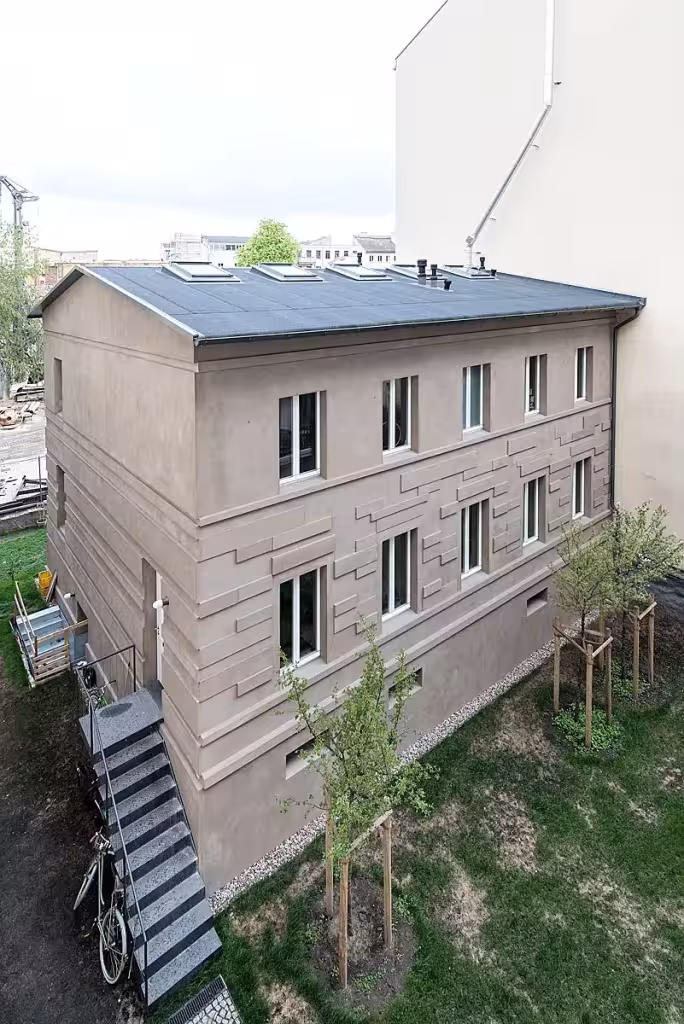 Fachada trasera de la Casa MMB de asdfg Architekten en Prenzlauer Berg, de revoco gris con escalera exterior