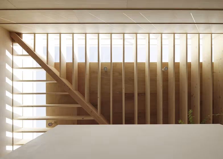 Atsushi y Mayumi Kawamoto del estudio mA-style Architects Light house Escalera de madera tras un entramado de listones verticales que filtra la luz en la Light Walls House