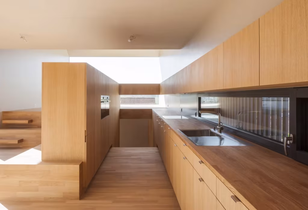 Cocina de roble con encimera continua y claraboya cenital en la casa de Berrel Berrel Kräutler en Rodersdorf